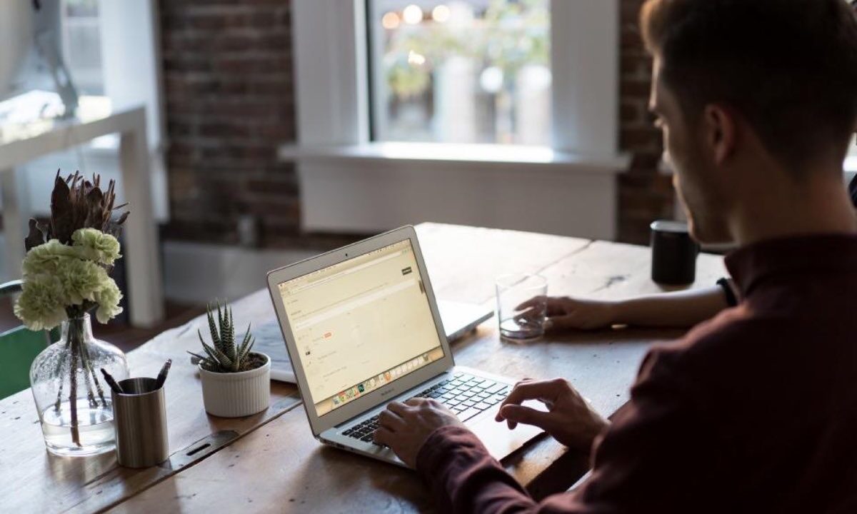 Mains au clavier sur un poste de travail chargé