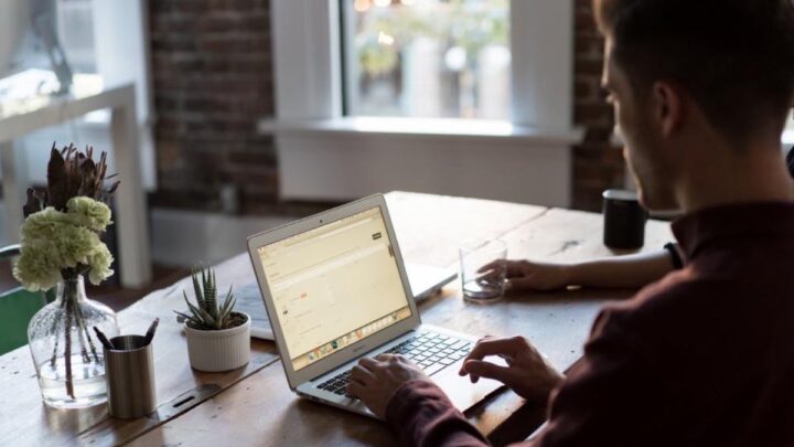 Mains au clavier sur un poste de travail chargé