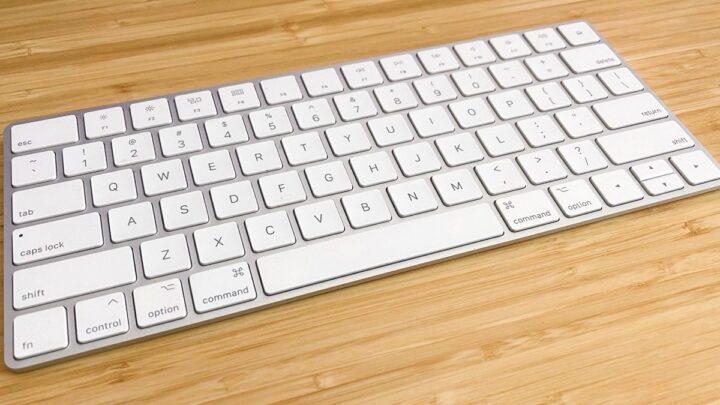 Clavier blanc posé sur un bureau en bambou